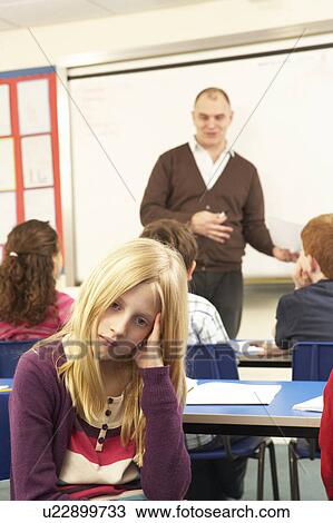Stock Image - Schoolchildren Studying In Classroom With Teacher. Fotosearch