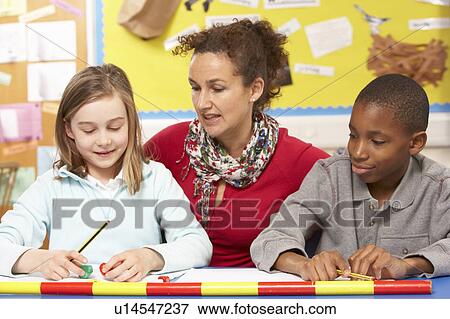 Schoolchildren Studying in classroom with teacher View Large Photo Image Stock Photo - Schoolchildren Studying in classroom with teacher. Fotosearch
