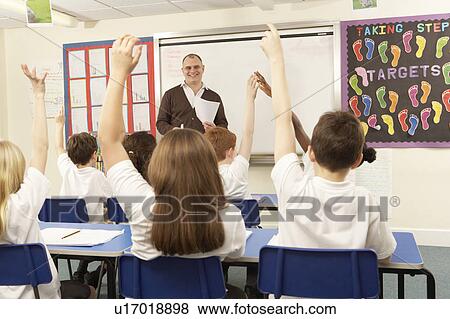 Stock Photo - Schoolchildren Studying In Classroom With Teacher. Fotosearch