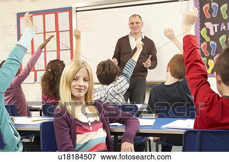 Stock Photo - Schoolchildren Studying In Classroom With Teacher. Fotosearch