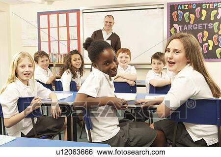 Schoolchildren Studying In Classroom With Teacher View Large Photo Image Stock Photograph - Schoolchildren Studying In Classroom With Teacher. Fotosearch