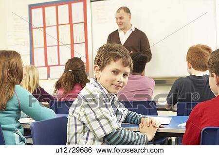 Stock Photograph - Schoolchildren Studying In Classroom With Teacher. Fotosearch