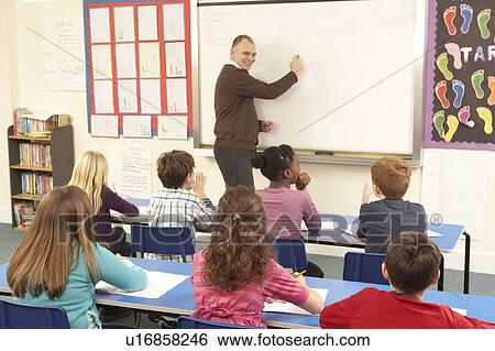 Stock Photograph - Schoolchildren Studying In Classroom With Teacher. Fotosearch