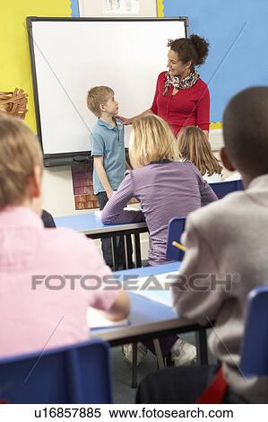 Stock Photography - Schoolchildren Studying In Classroom With Teacher. Fotosearch