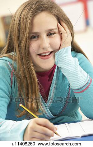Stock Image - Schoolgirl Studying In Classroom. Fotosearch