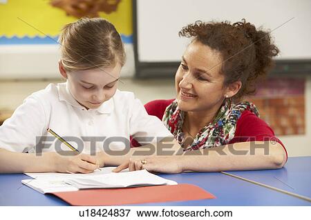 Schoolgirl Studying In Classroom With Teacher View Large Photo Image Stock Photo - Schoolgirl Studying In Classroom With Teacher. Fotosearch