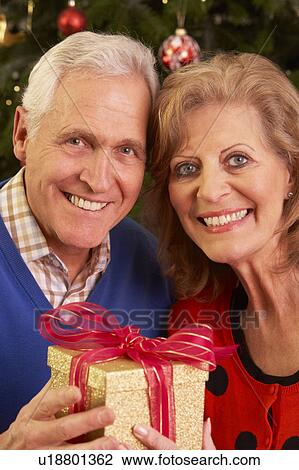 Senior Couple Exchanging Christmas Gifts View Large Photo Image Stock Image - Senior Couple Exchanging Christmas Gifts. Fotosearch