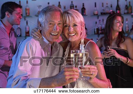 Picture - Senior Couple Having Fun In Busy Bar. Fotosearch
