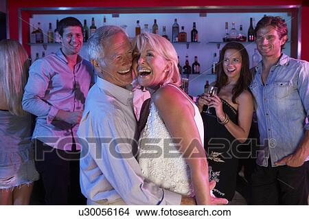 Picture - Senior Couple Having Fun In Busy Bar. Fotosearch