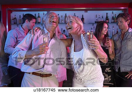 Stock Photography - Senior Couple Having Fun In Busy Bar. Fotosearch