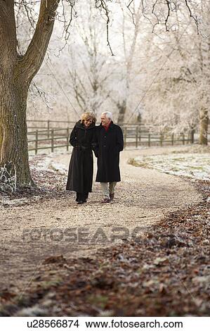 Picture - Senior Couple On Winter Walk Through Frosty Landscape. Fotosearch