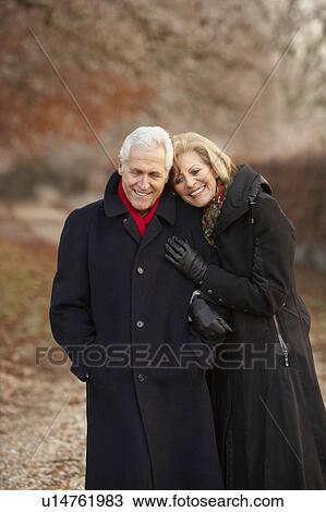 Stock Image - Senior Couple On Winter Walk Through Frosty Landscape. Fotosearch