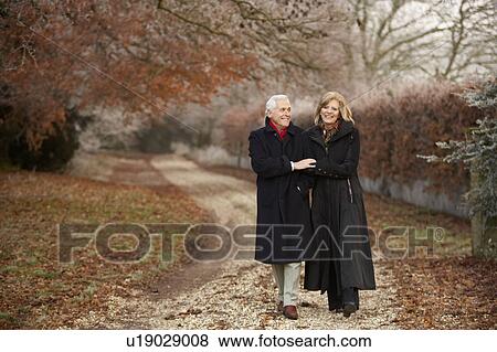 Stock Photo - Senior Couple On Winter Walk Through Frosty Landscape. Fotosearch