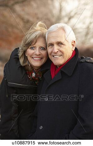 Stock Photography - Senior Couple On Winter Walk Through Frosty Landscape. Fotosearch