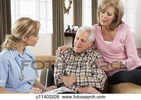 Stock Photo - Senior Couple Talking To Health Visitor At Home. Fotosearch