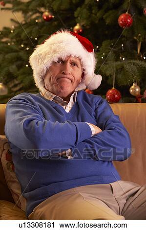 Senior Man Dressed As Father Christmas Looking Grumpy In Front Of Christmas Tree View Large Photo Image Stock Image - Senior Man Dressed As Father Christmas Looking Grumpy In Front Of Christmas Tree. Fotosearch
