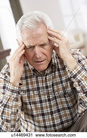 Stock Image - Senior Man Looking Stressed In Chair At Home. Fotosearch