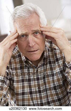 Stock Image - Senior Man Looking Stressed In Chair At Home. Fotosearch