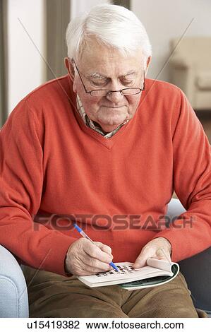Senior Man Relaxing In Chair At Home Completing Crossword View Large Photo Image Stock Image - Senior Man Relaxing In Chair At Home Completing Crossword. Fotosearch