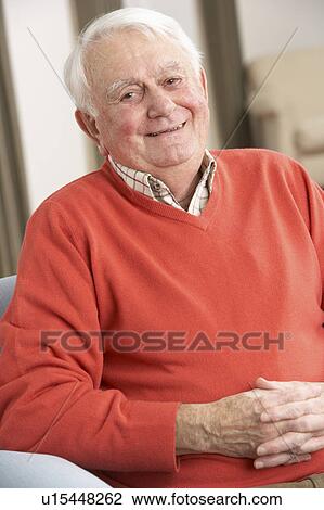 Stock Image - Senior Man Relaxing In Chair At Home. Fotosearch