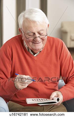 Senior Man Relaxing In Chair At Home Completing Crossword View Large Photo Image Stock Image - Senior Man Relaxing In Chair At Home Completing Crossword. Fotosearch