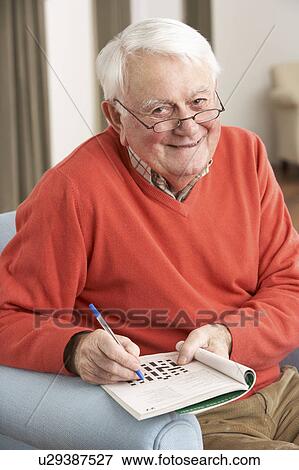 Senior Man Relaxing In Chair At Home Completing Crossword View Large Photo Image Stock Photo - Senior Man Relaxing In Chair At Home Completing Crossword. Fotosearch