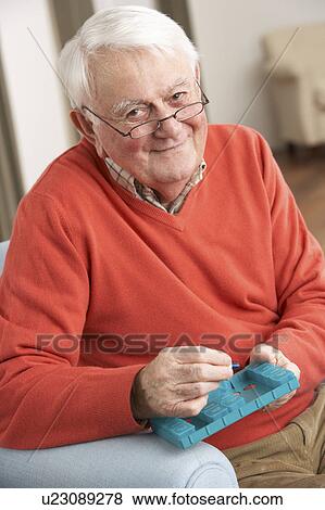 Senior Man Sorting Medication Using Organiser At Home View Large Photo Image Stock Photo - Senior Man Sorting Medication Using Organiser At Home. Fotosearch
