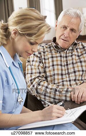 Stock Photo - Senior Man Talking To Health Visitor At Home. Fotosearch