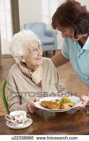 Senior Woman Being Served Meal By Carer View Large Photo Image Stock Photograph - Senior Woman Being Served Meal By Carer. Fotosearch