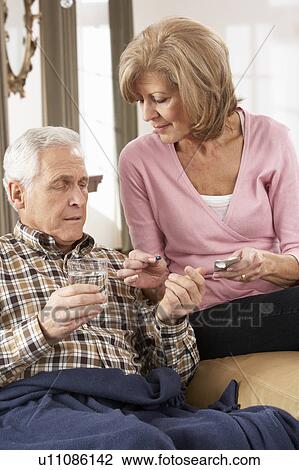 Stock Image - Senior Woman Caring For Sick Husband. Fotosearch