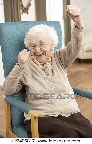 Senior Woman Celebrating In Chair At Home View Large Photo Image Stock Photo - Senior Woman Celebrating In Chair At Home. Fotosearch