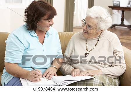 Picture - Senior Woman In Discussion With Health Visitor At Home. Fotosearch