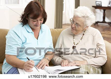 Stock Photo - Senior Woman In Discussion With Health Visitor At Home. Fotosearch