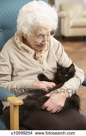 Senior Woman Relaxing In Chair At Home With Pet Cat View Large Photo Image Picture - Senior Woman Relaxing In Chair At Home With Pet Cat. Fotosearch