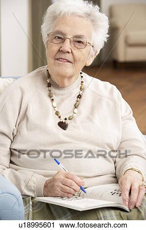 Senior Woman Relaxing In Chair At Home Completing Crossword View Large Photo Image Stock Image - Senior Woman Relaxing In Chair At Home Completing Crossword. Fotosearch