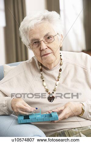 Senior Woman Sorting Medication Using Organiser At Home View Large Photo Image Stock Photo - Senior Woman Sorting Medication Using Organiser At Home. Fotosearch