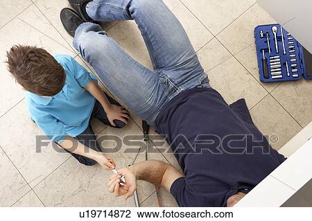 Son Helping Father To Mend Sink In Kitchen View Large Photo Image Stock Image - Son Helping Father To Mend Sink In Kitchen. Fotosearch