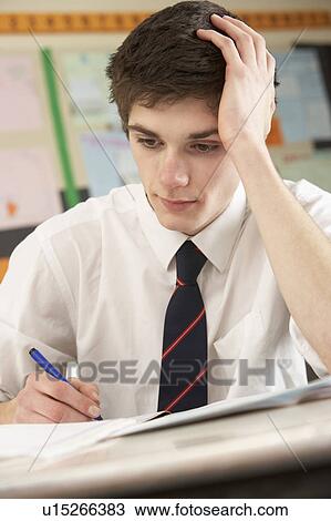 Stressed Male Teenage Student Studying In Classroom View Large Photo Image Stock Image - Stressed Male Teenage Student Studying In Classroom. Fotosearch
