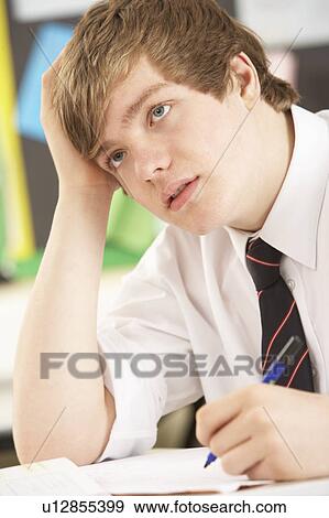 Stressed Male Teenage Student Studying In Classroom View Large Photo Image Stock Photo - Stressed Male Teenage Student Studying In Classroom. Fotosearch