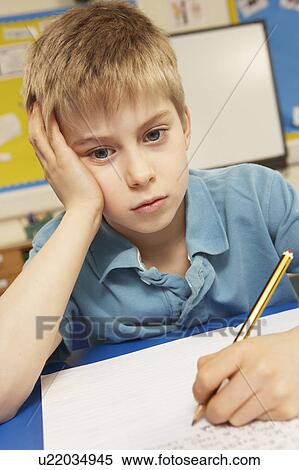 Stock Photography - Stressed Schoolboy Studying In Classroom. Fotosearch