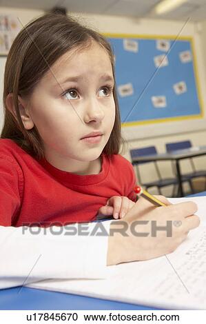 Stock Image - Stressed Schoolgirl Studying In Classroom. Fotosearch
