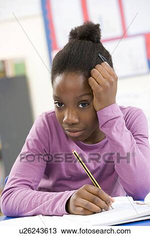 Stock Image - Stressed Schoolgirl Studying In Classroom. Fotosearch