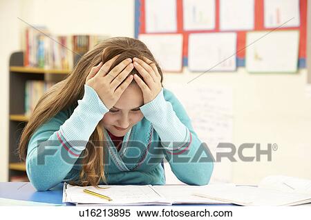 Stock Photography - Stressed Schoolgirl Studying In Classroom. Fotosearch