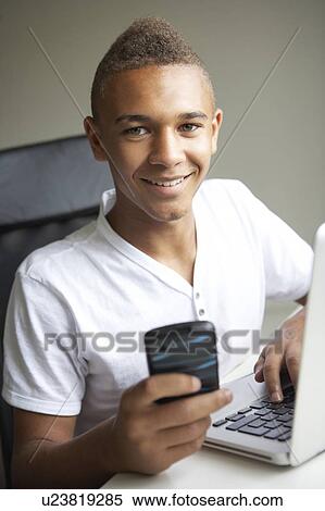 Teenage Boy Using Laptop And Mobile At Home View Large Photo Image Stock Photography - Teenage Boy Using Laptop And Mobile At Home. Fotosearch