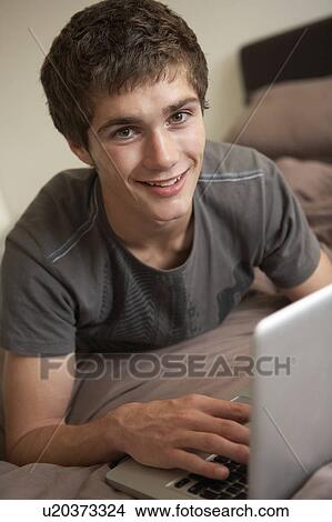 Picture - Teenage Boy Using Laptop At Home. Fotosearch