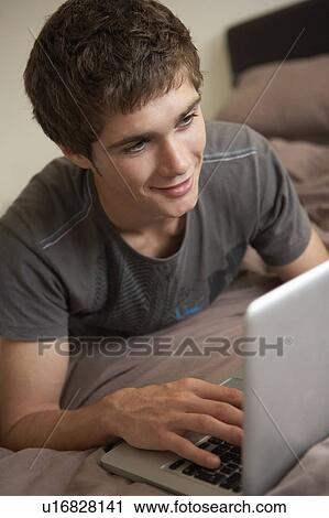 Teenage Boy Using Laptop At Home View Large Photo Image Stock Image - Teenage Boy Using Laptop At Home. Fotosearch