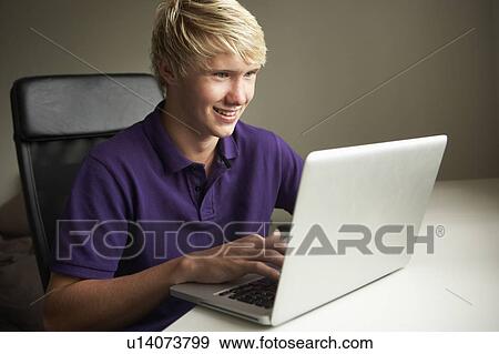 Teenage Boy Using Laptop At Home View Large Photo Image Stock Photo - Teenage Boy Using Laptop At Home. Fotosearch