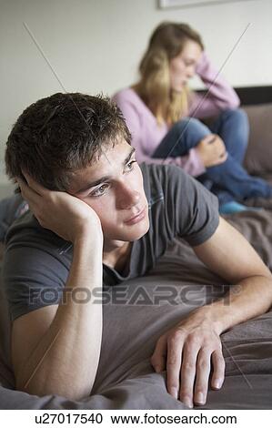 Stock Image - Teenage Couple In Bedroom After Argument. Fotosearch