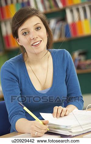 Stock Image - Teenage Female Student In Working In Classroom. Fotosearch