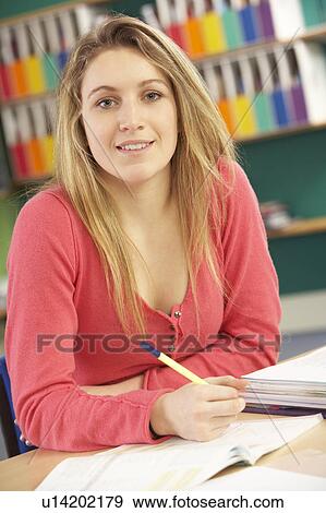 Stock Photo - Teenage Female Student In Working In Classroom. Fotosearch